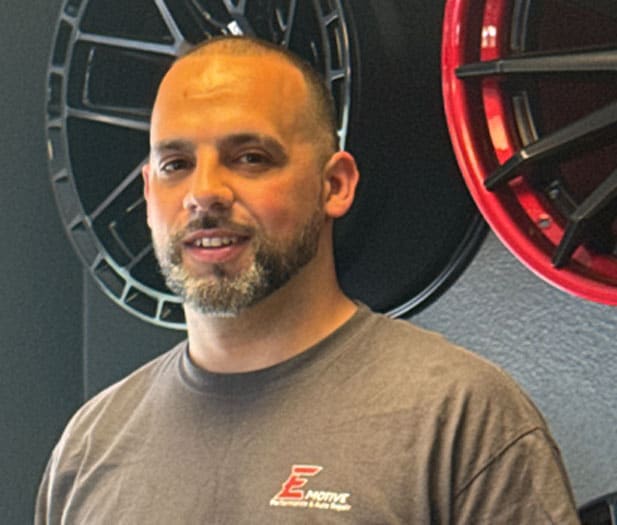 a man standing in front of a wall with rims